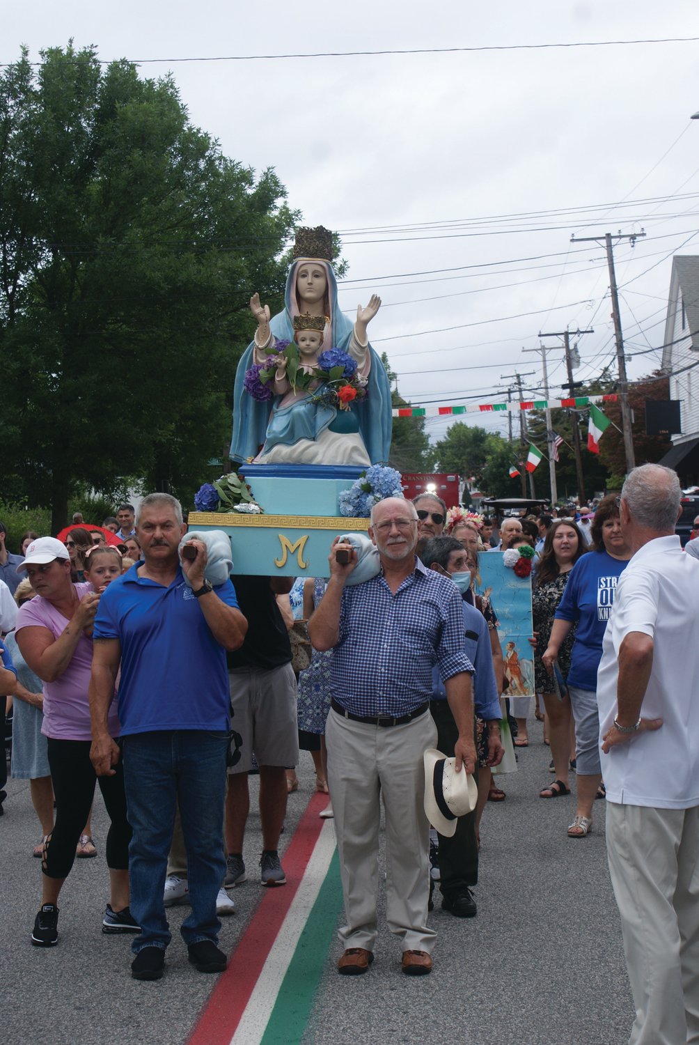 THE MADONNA: The traditional carrying of the Madonna is seen during the St. Mary’s Feast procession, held after the 10 a.m. Mass on Sunday. 